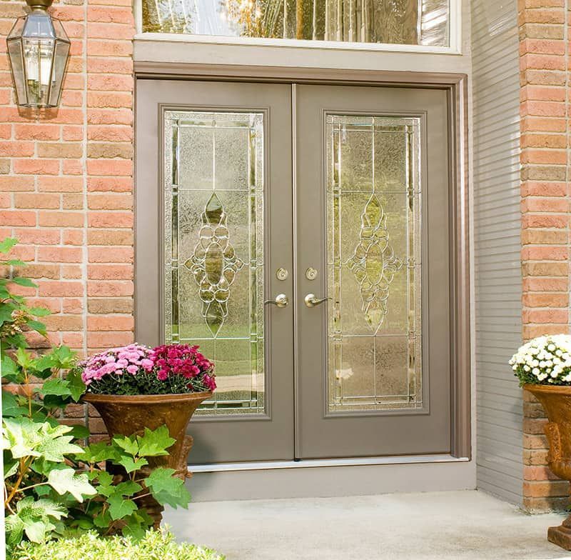 Wooden front door with sidelights, set in a light teal wall. Wooden front door with sidelights, set in a light teal wall.