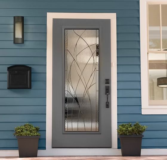 Gray front door with decorative glass, blue siding, mailbox, and potted plants. Gray front door with decorative glass, blue siding, mailbox, and potted plants.