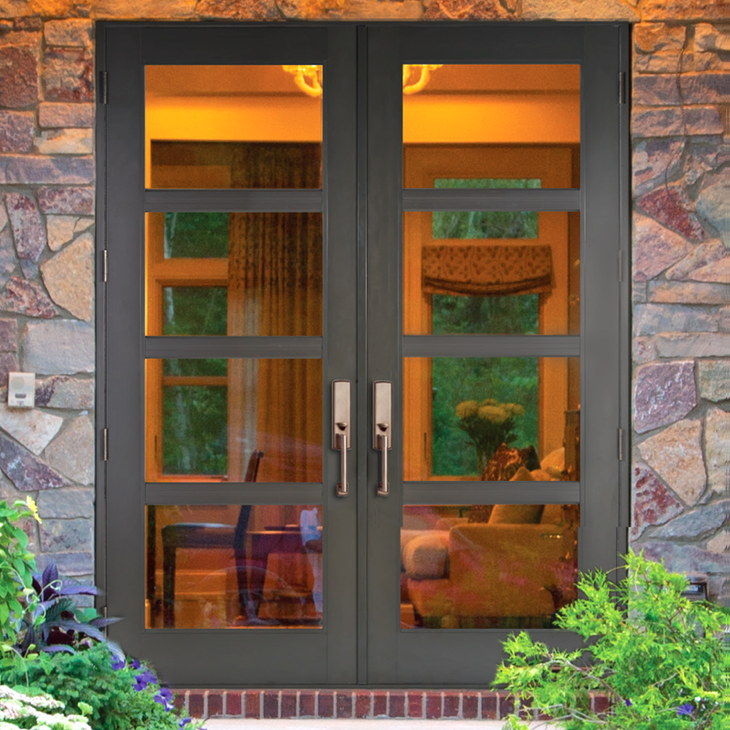 Double black doors with rectangular glass panes, set in a stone wall, leading inside; interior visible. Double black doors with rectangular glass panes, set in a stone wall, leading inside; interior visible.