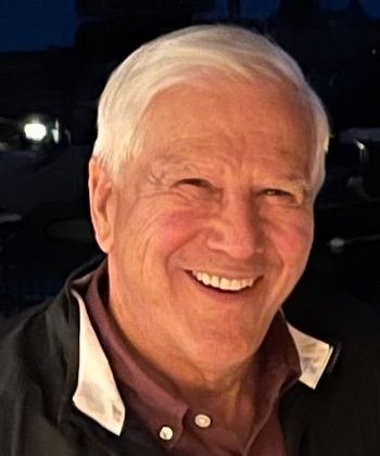 A man with white hair is smiling for the camera.