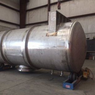 Large, silver, cylindrical tank in a warehouse.