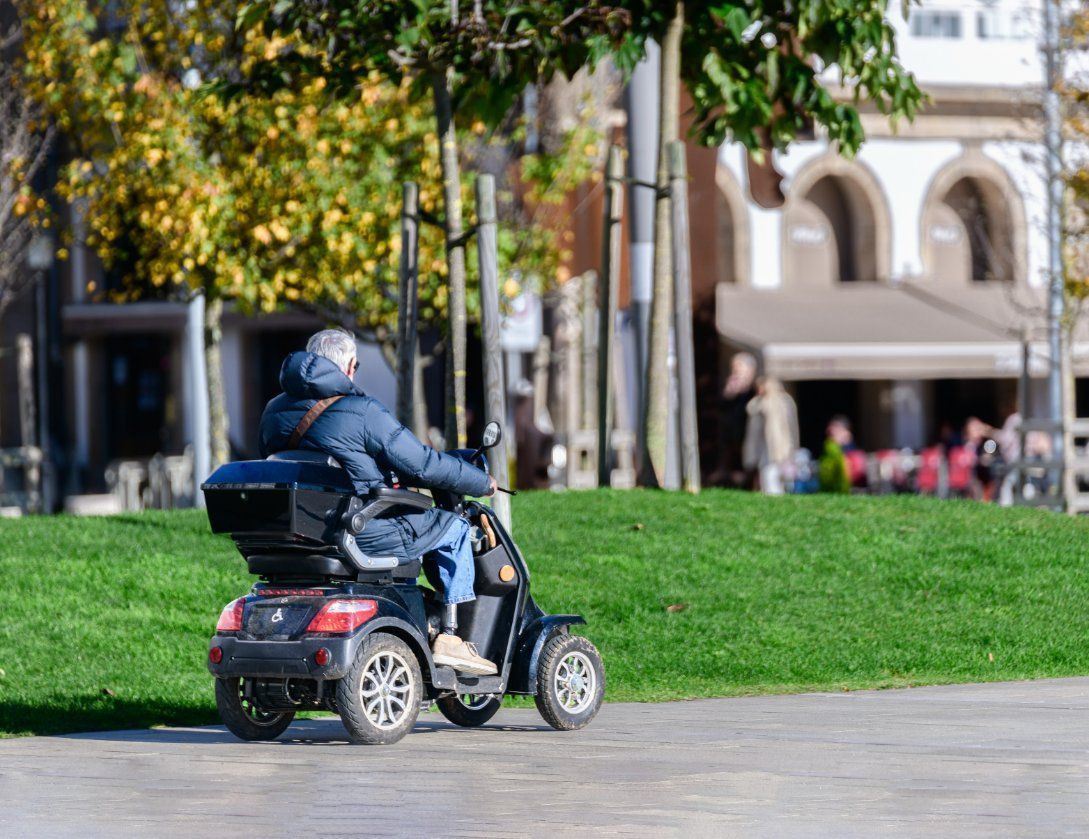 A man is riding a mobility scooter in a park — Toukley World of Bikes In Toukley, NSW