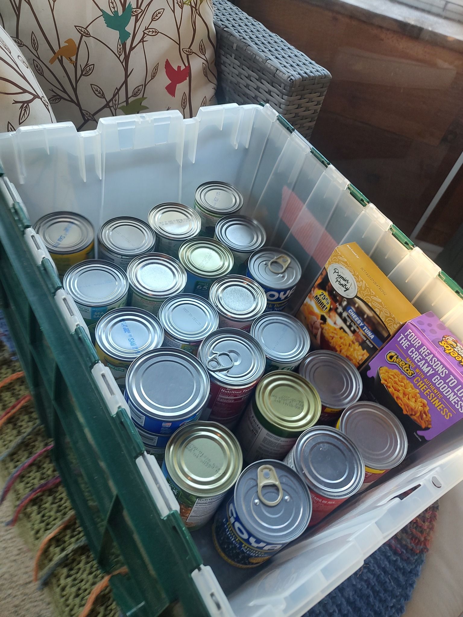 Crate filled with assorted canned goods and packaged food items.