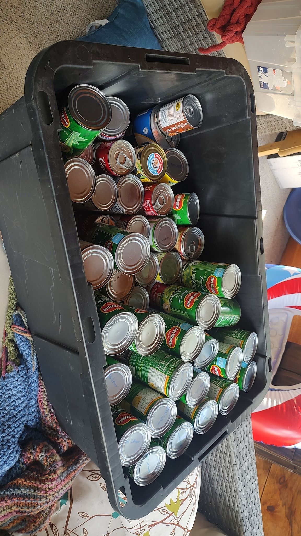 Open cooler filled with assorted drink cans and bottles on a patterned floor.