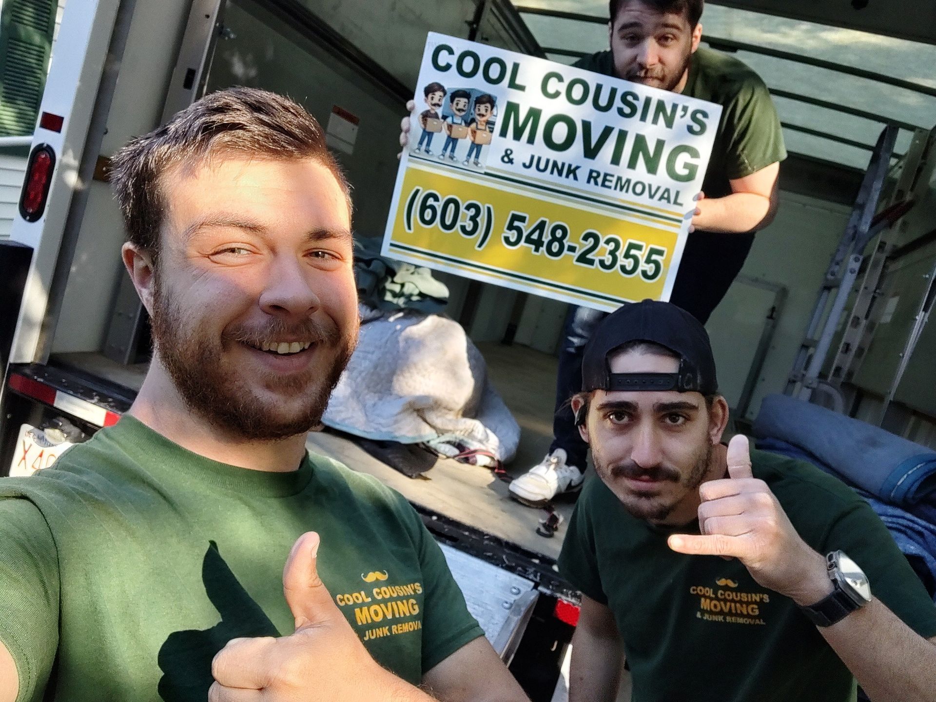 Two movers posing with a truck and sign for Cool Cousins Moving and Junk Removal.