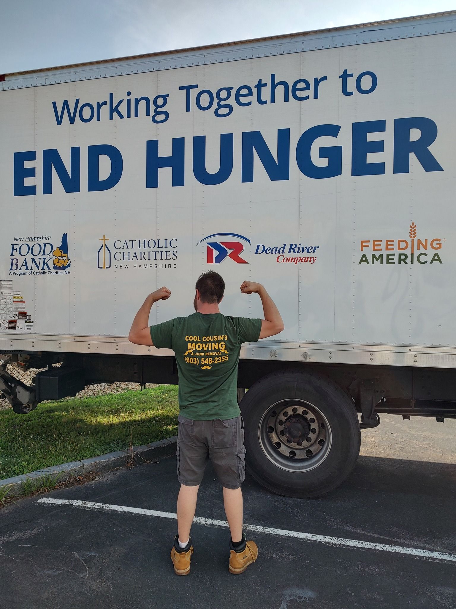 Person flexes in front of a white truck reading “Working Together to END HUNGER.”