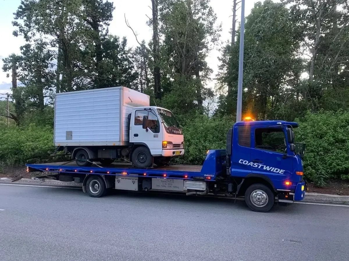Blue Tow Truck Carrying White Truck in Newcastle