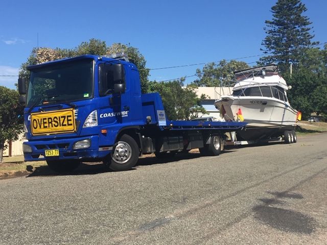 A Blue Tow Truck With a Yellow Sign That Says 'oversized' on It — Coastwide Towing & Transport In Berkeley Vale, NSW