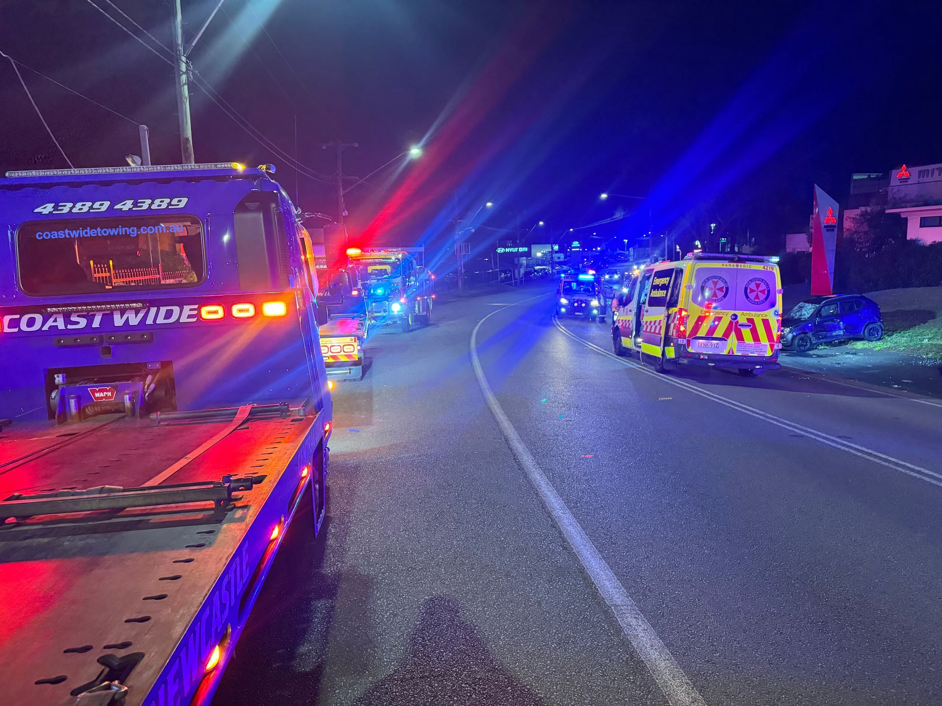 Emergency vehicles at night, tow truck with flashing lights, accident scene on road. — Coastwide Towing & Transport In Berkeley Vale, NSW
