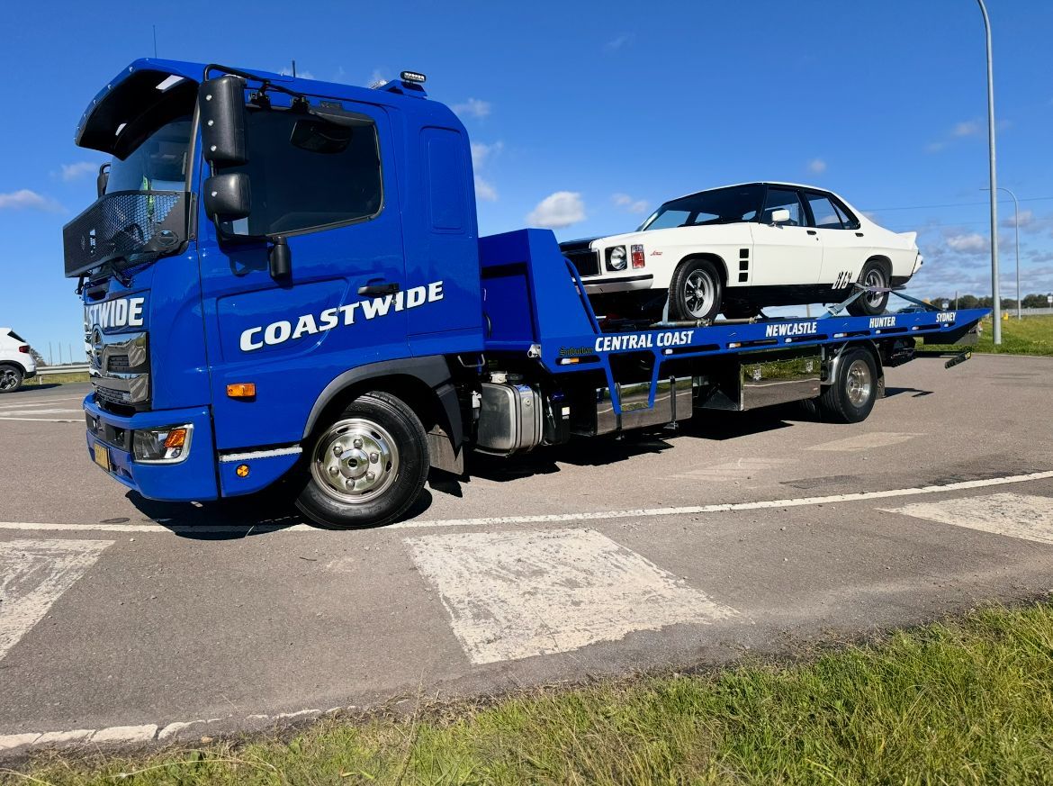 A Blue Coastwide Tow Truck Is Parked On The Side Of The Road — Coastwide Towing & Transport In Hunter Valley, NSW