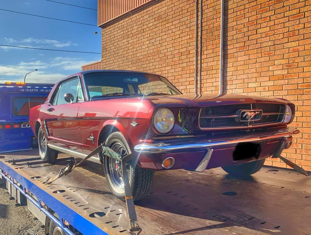 A Red Mustang Is Sitting On Top Of A Tow Truck — Coastwide Towing & Transport In Berkeley Vale, NSW