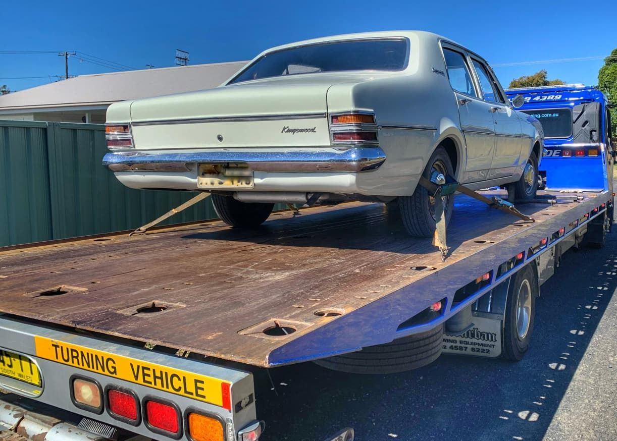 A Car Is Sitting On Top Of A Flatbed Tow Truck — Coastwide Towing & Transport In Gosford, NSW