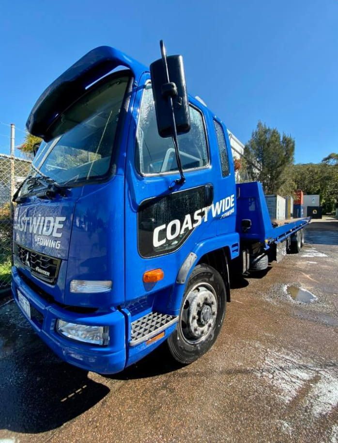 A Blue Coastwide Tow Truck Is Parked On The Side Of The Road — Coastwide Towing & Transport In Newcastle, NSW