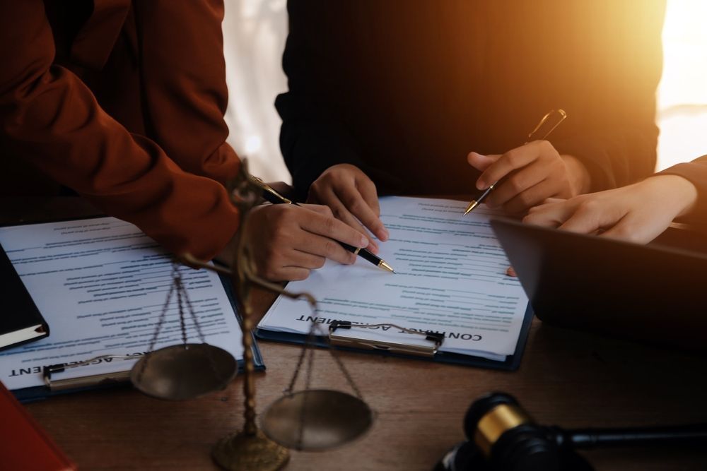 A group of people are sitting at a table signing a document.