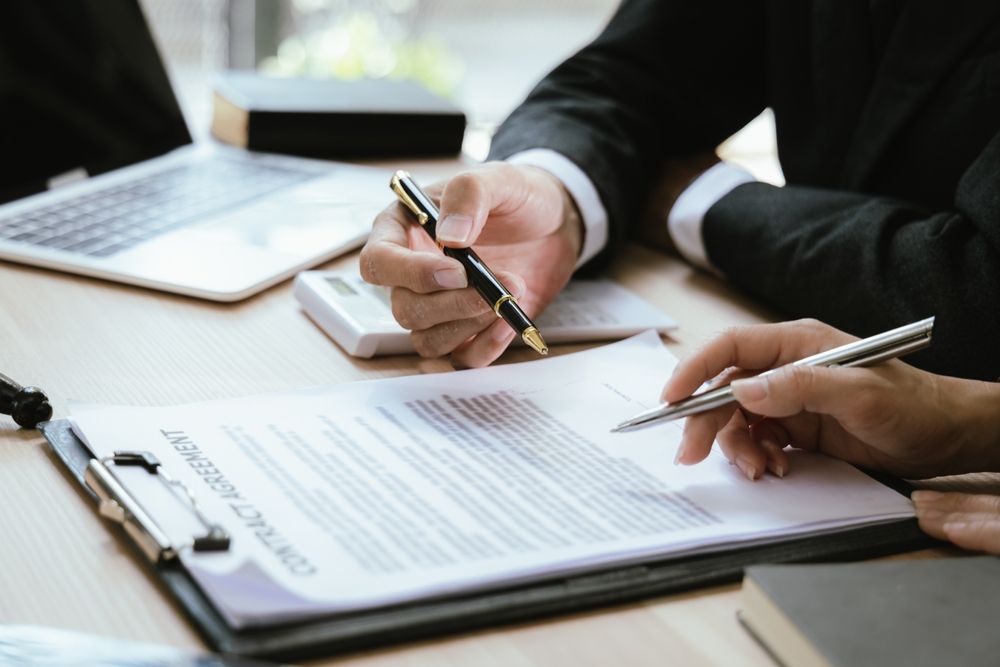 A man is holding a pen over a piece of paper.