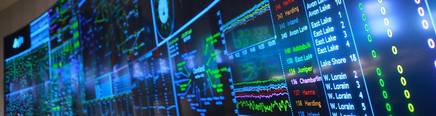 A large screen displaying complex data visualizations and information with a blue, green, and white color scheme.