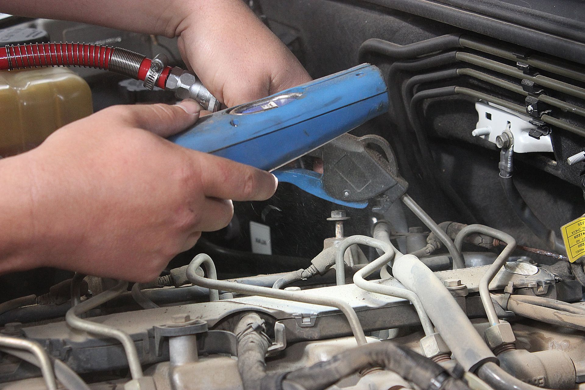 Mechanic Working in A Car Engine Bay, Tightening a Part Near Hoses and Wiring — Bay City A1 Tyres in North Geelong, VIC