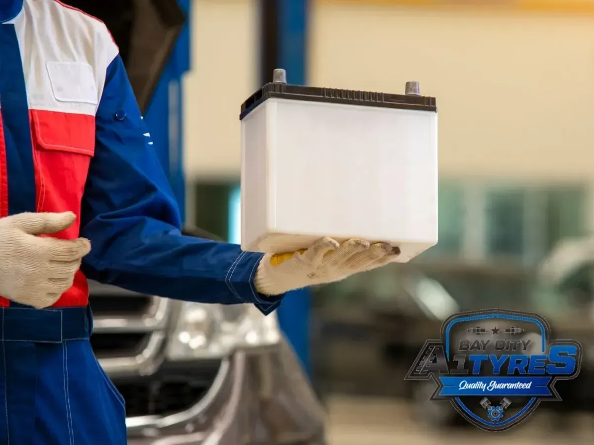 Gloved Worker Holding a White Lithium Battery — Bay City A1 Tyres in North Geelong, VIC