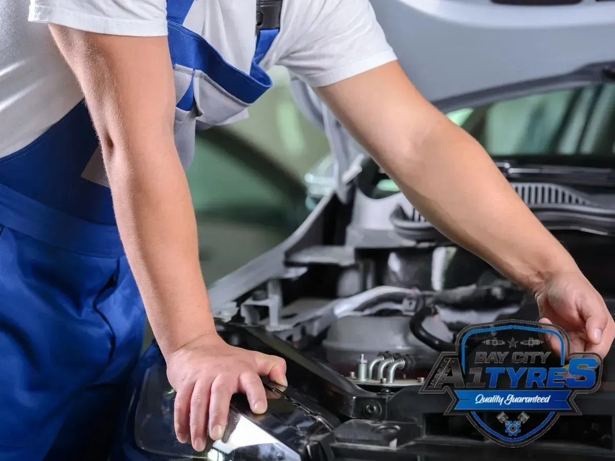 Mechanic in Blue Shirt Inspecting a Car Engine Under the Hood — Bay City A1 Tyres in North Geelong, VIC