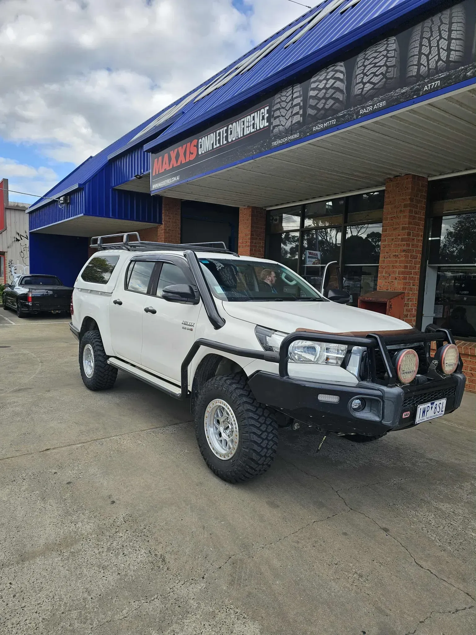 Blue Off-Road Suv Parked on Grass Beside a Green 4x4 in A Wooded Area — Bay City A1 Tyres in North Geelong, VIC