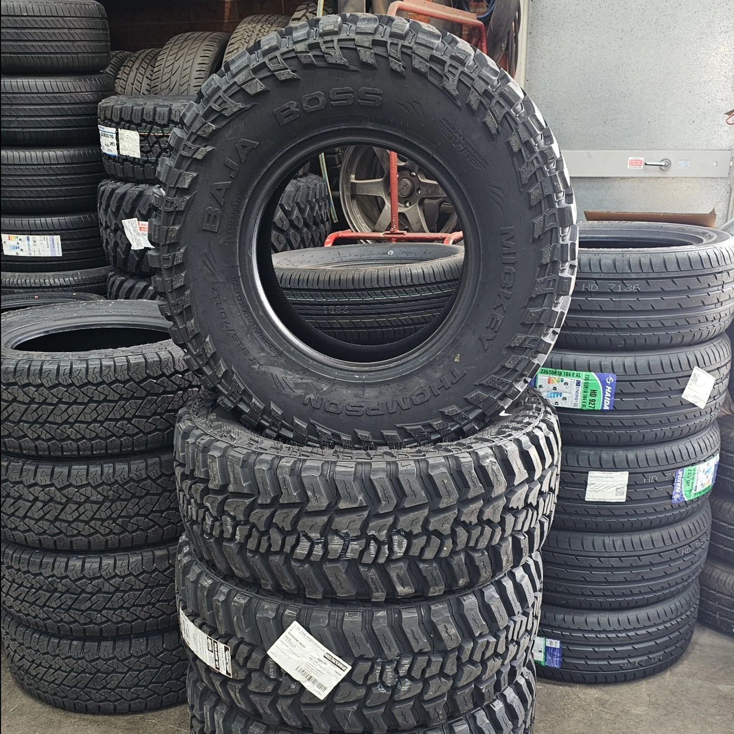 Stacked Black Tires in A Shop, with One Large Off-Road Tire Leaning on Top — Bay City A1 Tyres in North Geelong, VIC