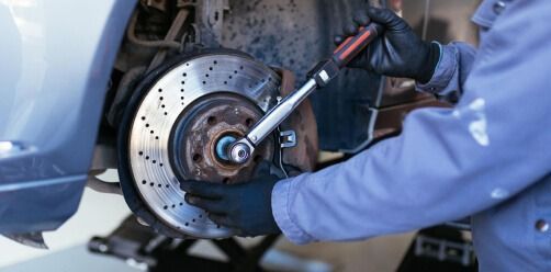 Mechanic Tightening A Car Brake Rotor With A Wrench — Bay City A1 Tyres in North Geelong, VIC