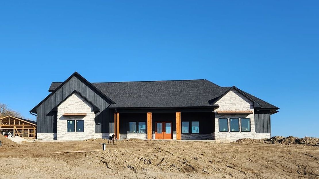 A large house is sitting on top of a dirt hill.
