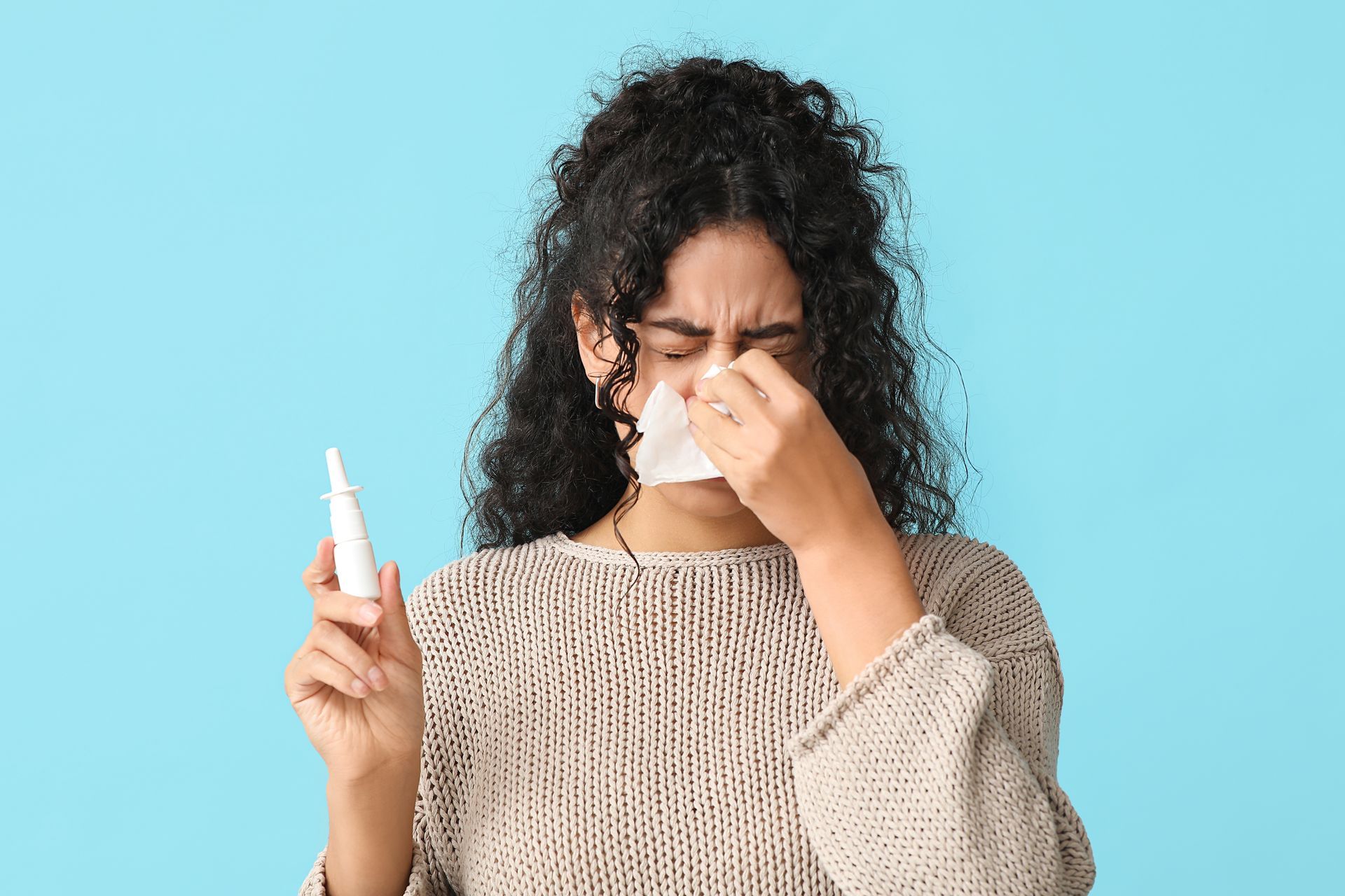 Person Holding a Tissue and Nasal Spray — Deception Bay Doctors In Deception Bay, QLD