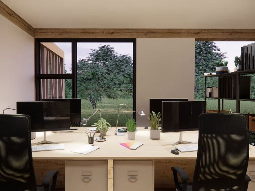 Intérieur de bureau avec bureaux, ordinateurs et une grande fenêtre donnant sur les arbres.