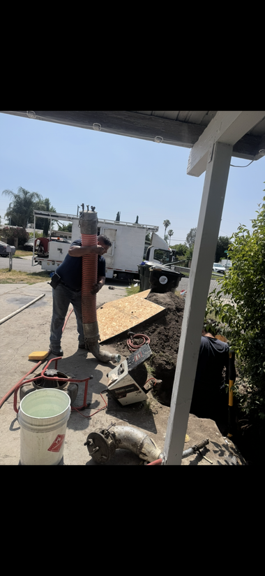 Rusty outdoor water faucet with a valve and hose connection against a concrete wall