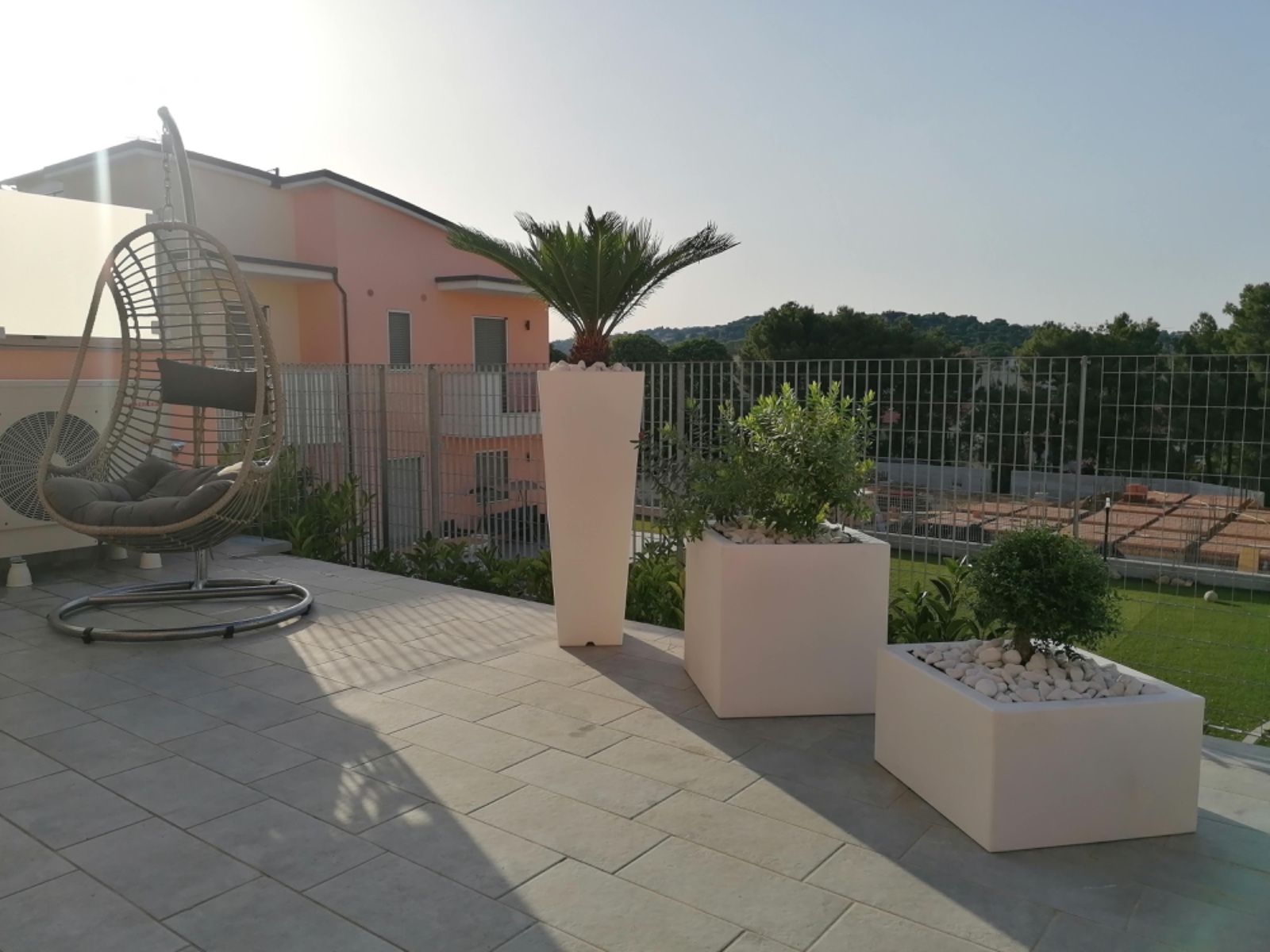 Varie piante in vaso e fioriere in ceramica vuote esposte su scaffali di legno in un negozio di giardinaggio