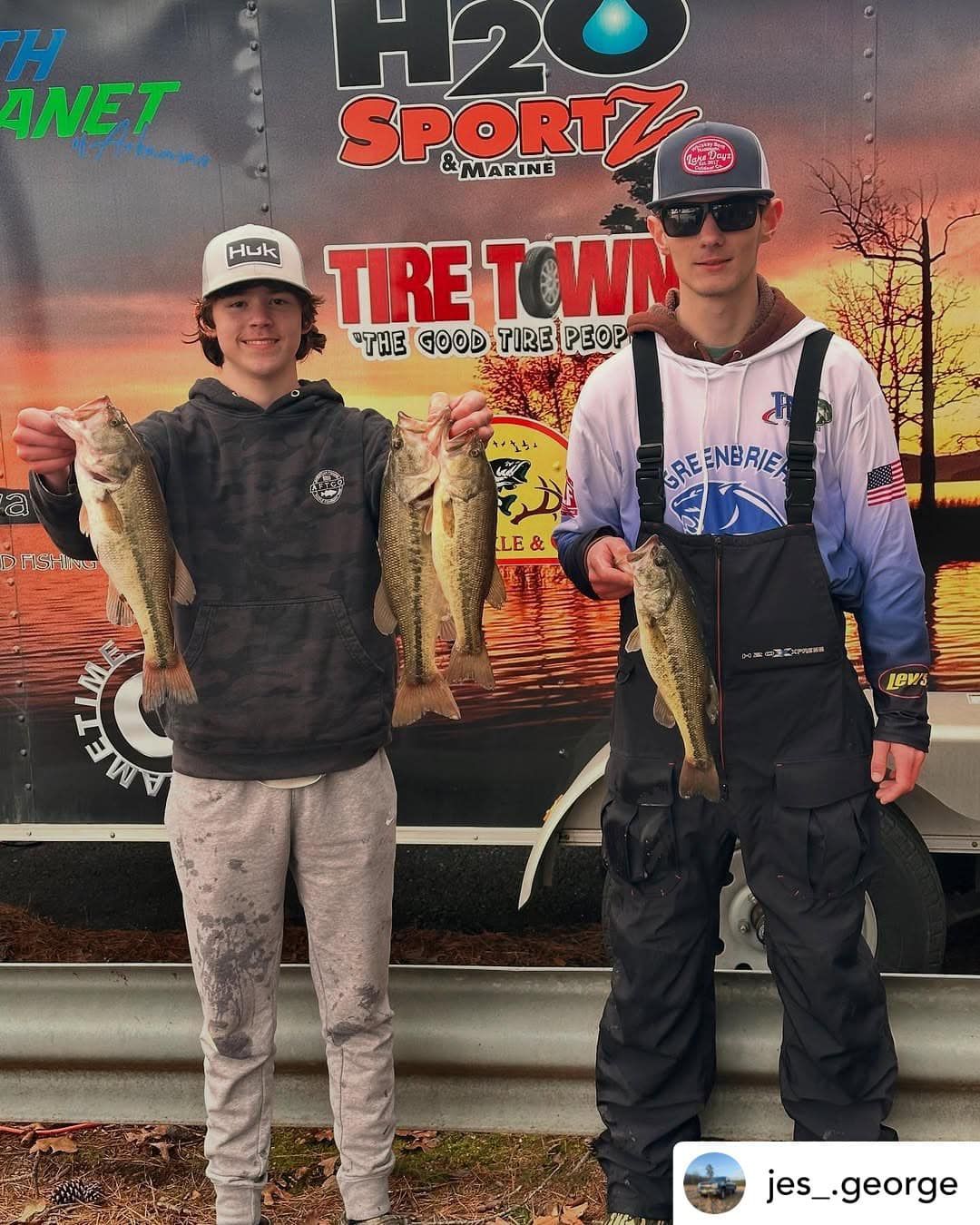 Two anglers posing with a large fish in front of a H2O Sportz truck at sunset