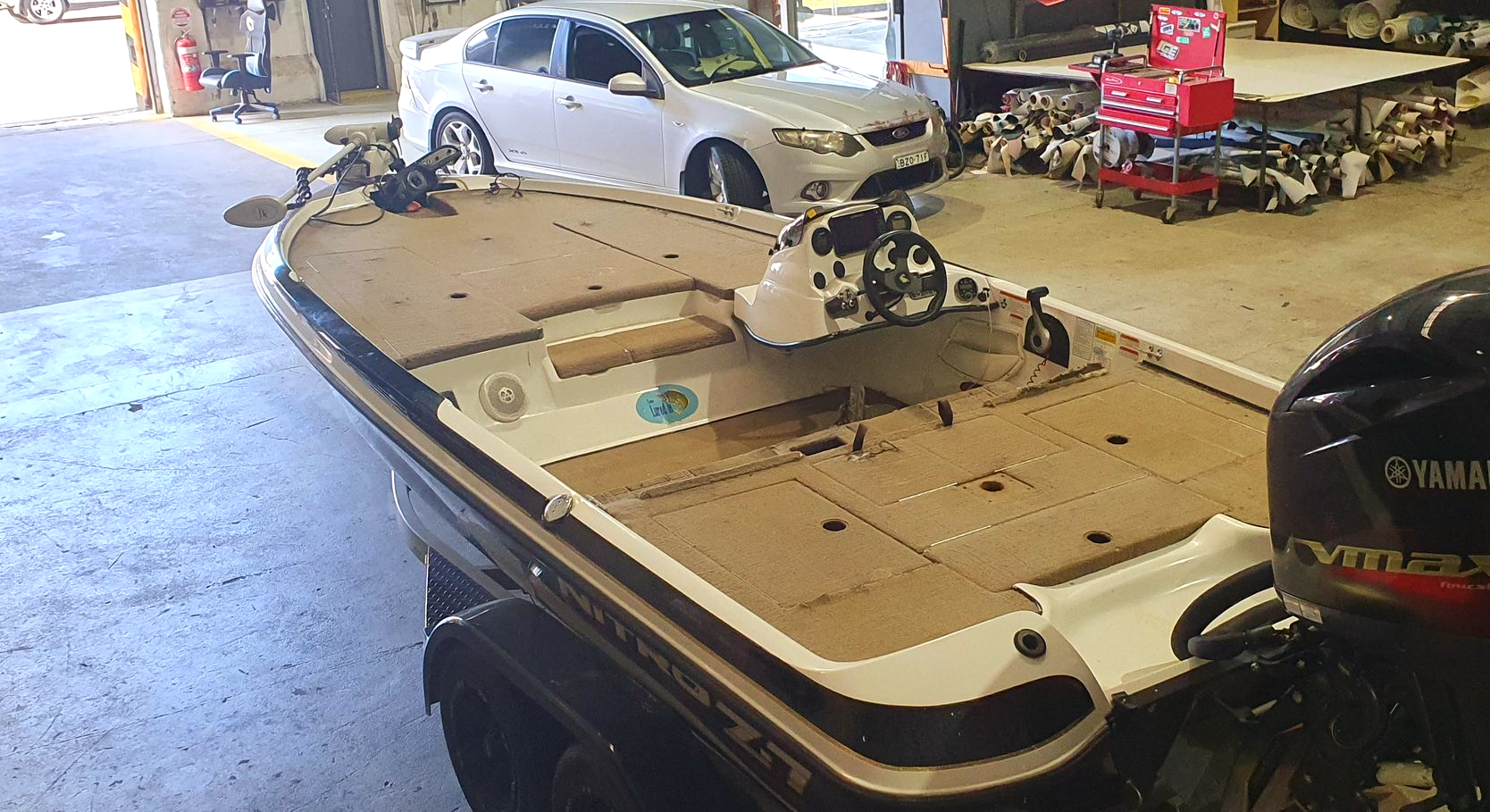 A bass boat with a white and black hull on a trailer inside a workshop — Tidy Trim Newcastle in Carrington, NSW