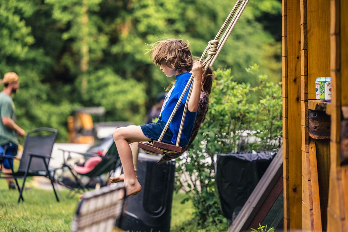 Kids swing on swings hanging with rope.