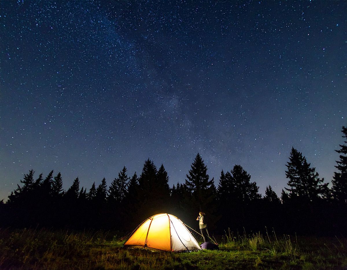 A tent sits under a starry sky.