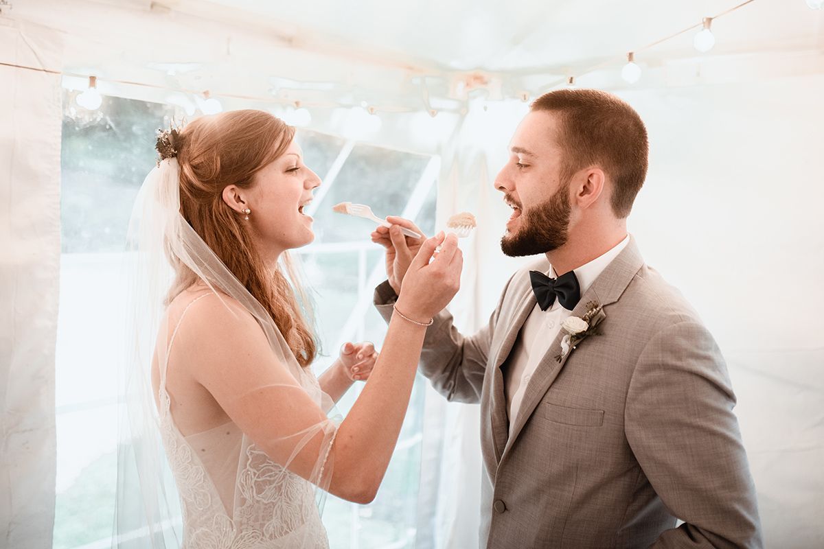 A bride and groom are eating cake.