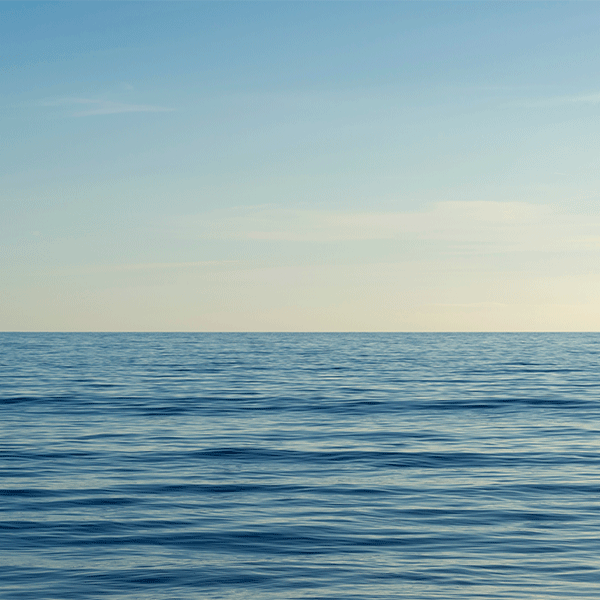 Blue ocean meeting a pale blue sky.