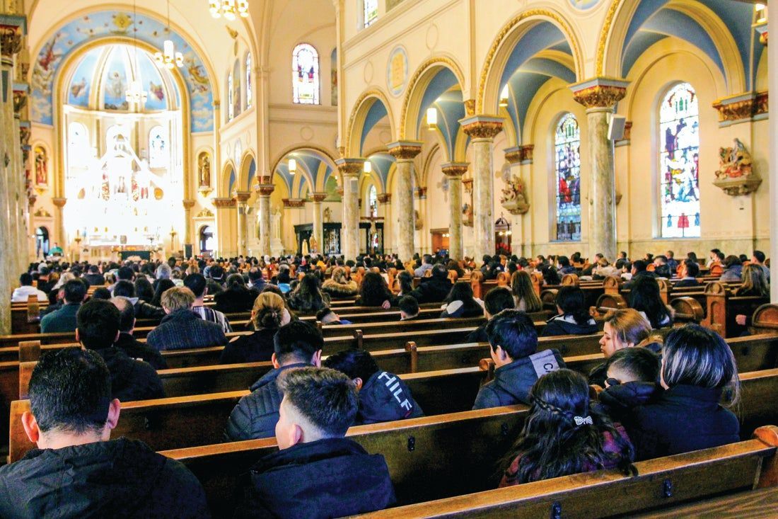 A church with a lot of people sitting in the pews.
