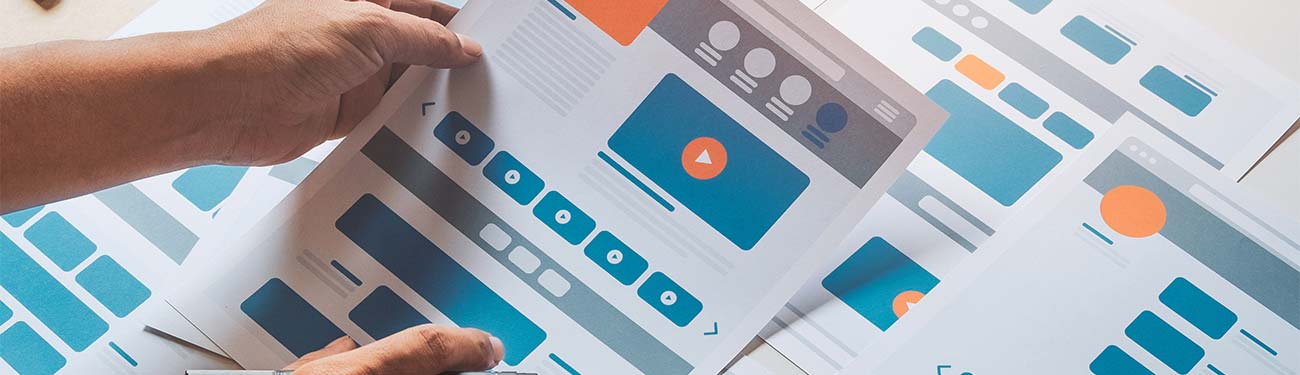A person is holding a piece of paper that has website navigation options depicted.