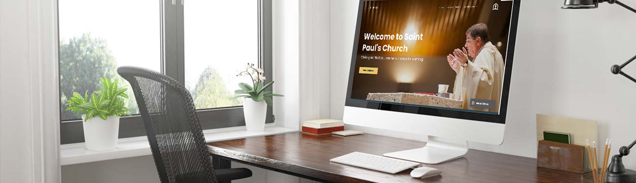 A computer is sitting on a desk in front of a window.
