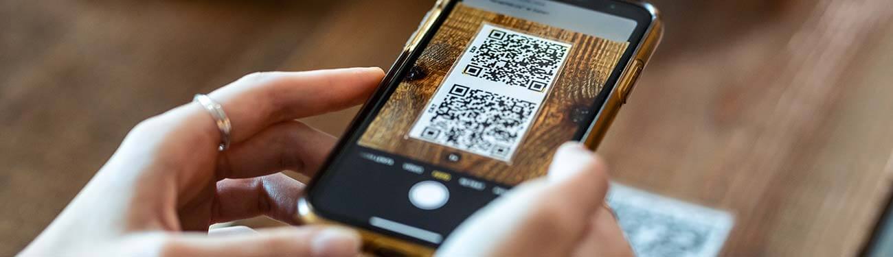 A person is taking a picture of a qr code on a cell phone.