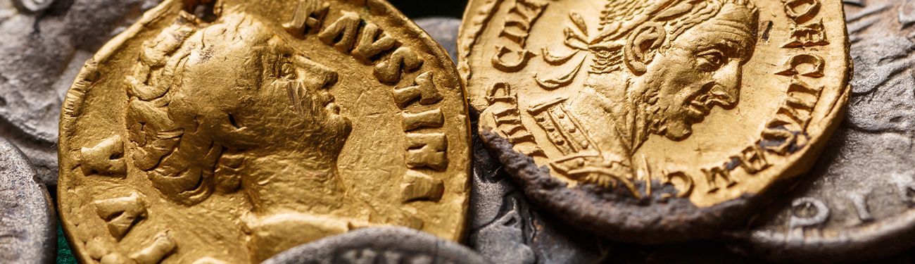 Ancient gold coins with engraved portraits and symbols, arranged closely together.