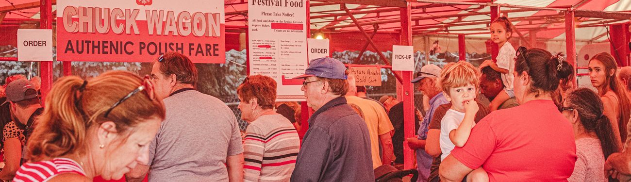 A crowd of people are standing in front of a chuck taylor authentic pork fair.