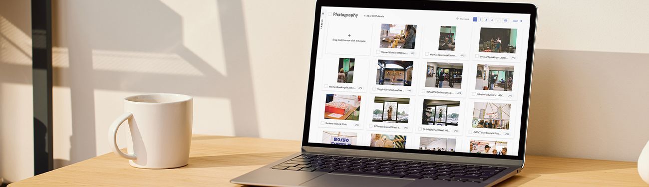 A laptop computer is sitting on a wooden desk next to a cup of coffee that is showing stock photography.