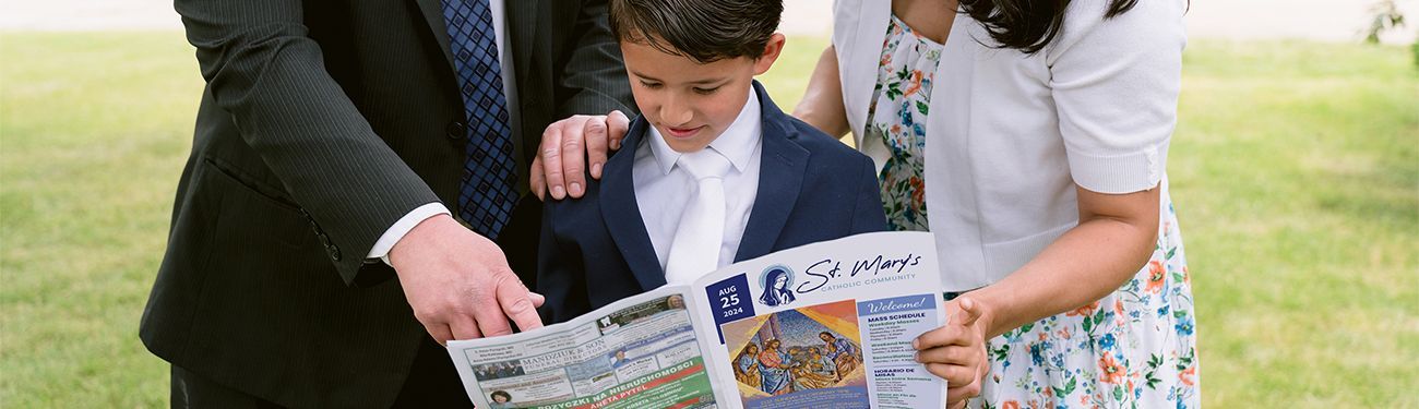 A family is looking at a bulletin together.