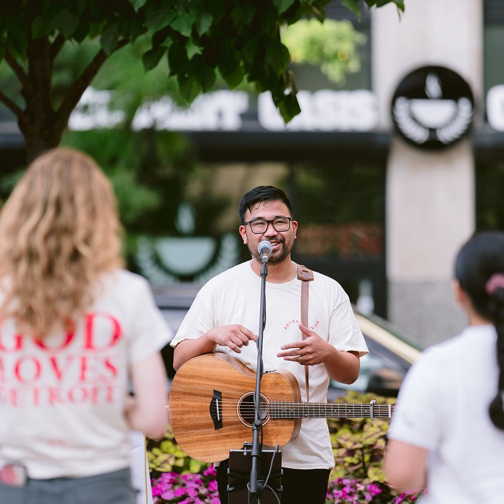 A man playing guitar at a church outreach event.