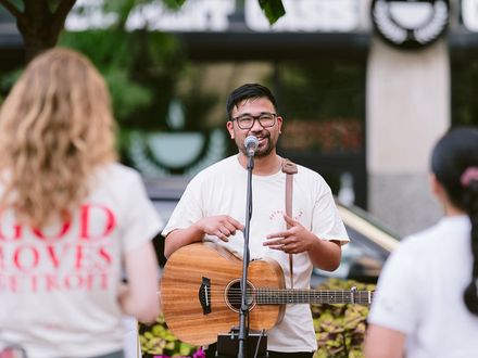 Man playing guitar at a church outreach event.