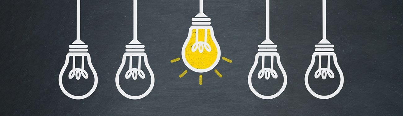 A group of light bulbs hanging from a string on a chalkboard.
