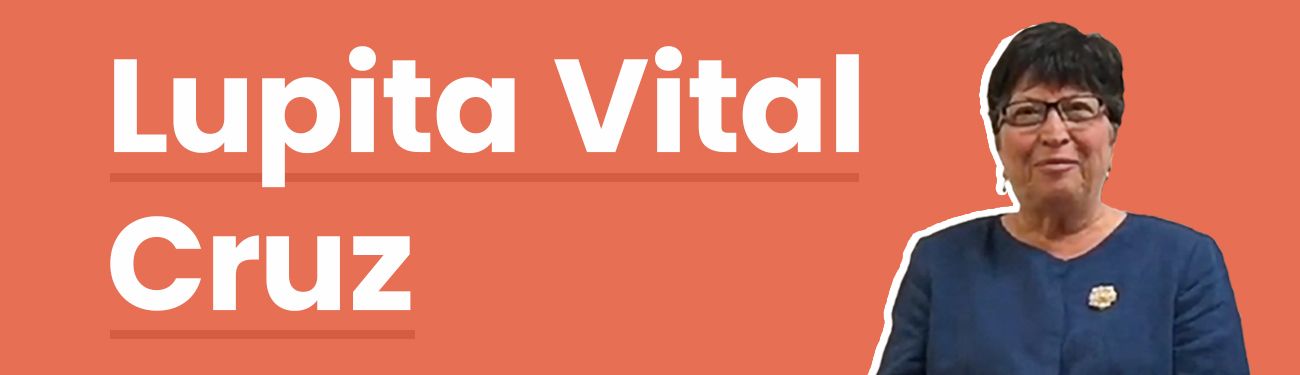A woman is standing in front of an orange background with the name Lupita Vital Cruz on it.