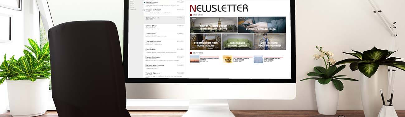 A computer monitor is sitting on a desk next to a chair showing a digital newsletter.